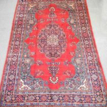 A Persian carpet, with a large central red medallion and all over floral designs, 360 x 230cm