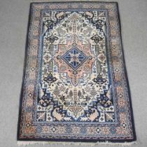 A Turkish woollen rug, with a central medallion, on a blue ground, 256 x 159cm
