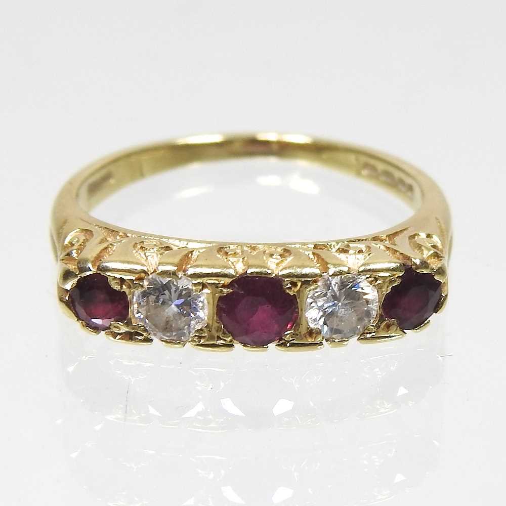 An 18 carat gold ruby and diamond ring, set with five alternating stones, 2.9g, size M, boxed