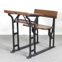 An early 20th century wooden school desk, on an iron frame 61w x 94d x 96h cm