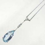 An 18 carat gold aquamarine and diamond pendant necklace, the pear shaped cushion cut stone weighing