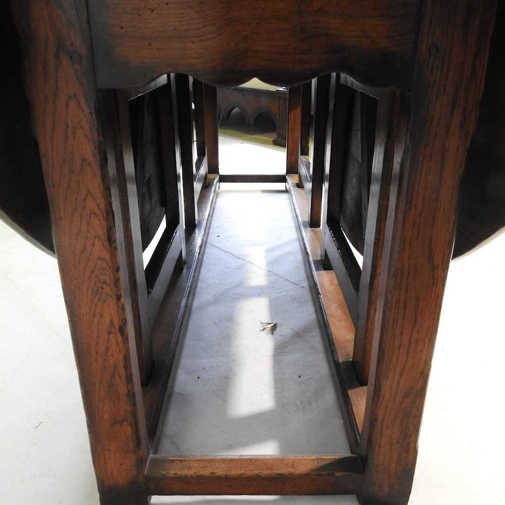 A large 18th century style oak wakes table, 20th century, the hinged oval top with a double gateleg, - Image 2 of 5