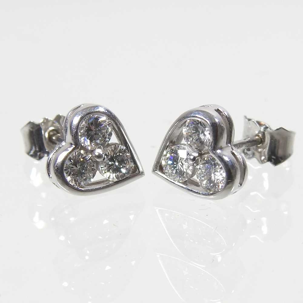 A pair of 18 carat white gold and diamond heart shaped earrings, each set with three, 1.9g,