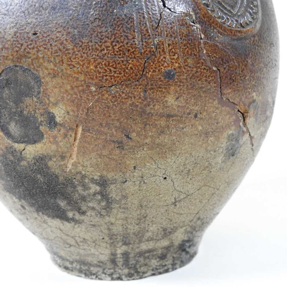 A 17th century German salt glazed stoneware bellarmine or Bartmann krug, of plain shape with a - Image 5 of 10