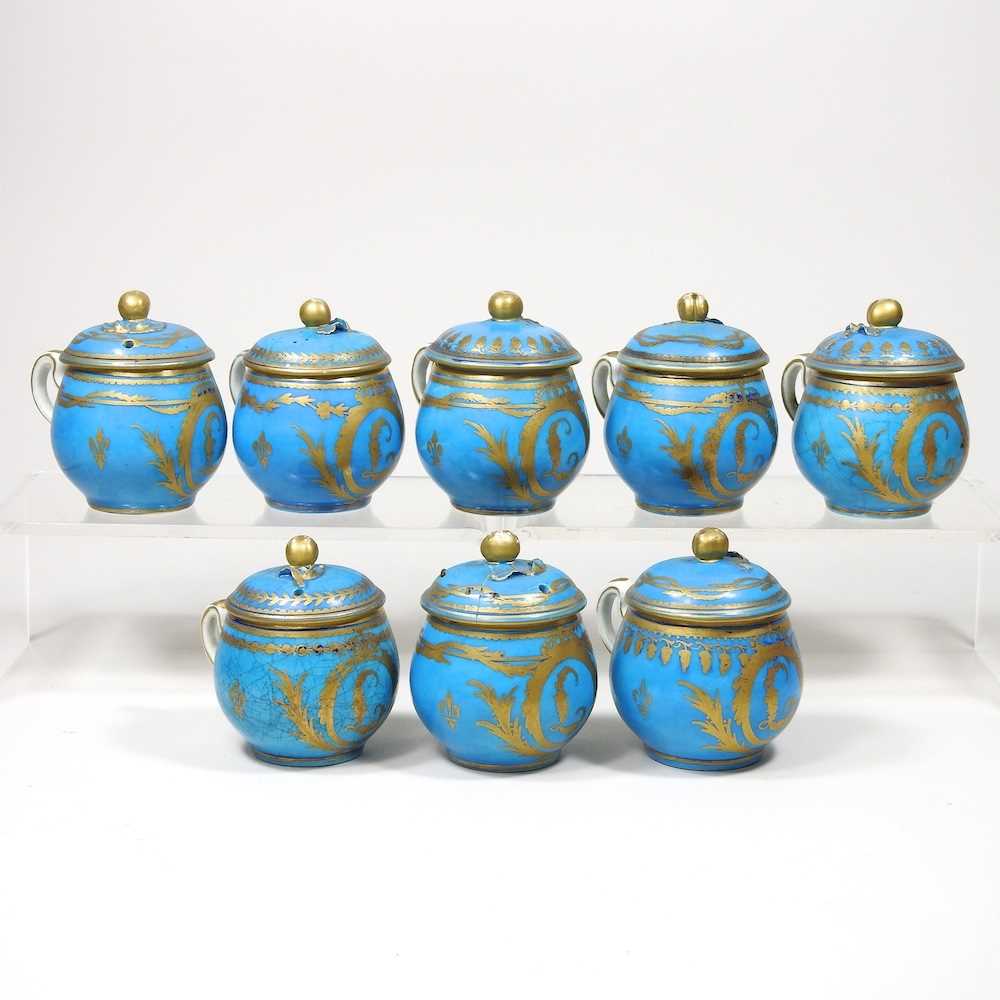 A set of eight 19th century Sevres porcelain custard cups and covers, with gilt decoration on a blue