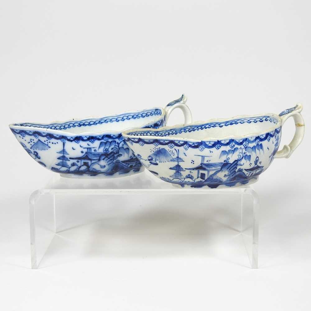 A pair of 18th century Staffordshire blue and white sauce boats, circa 1790, each painted with