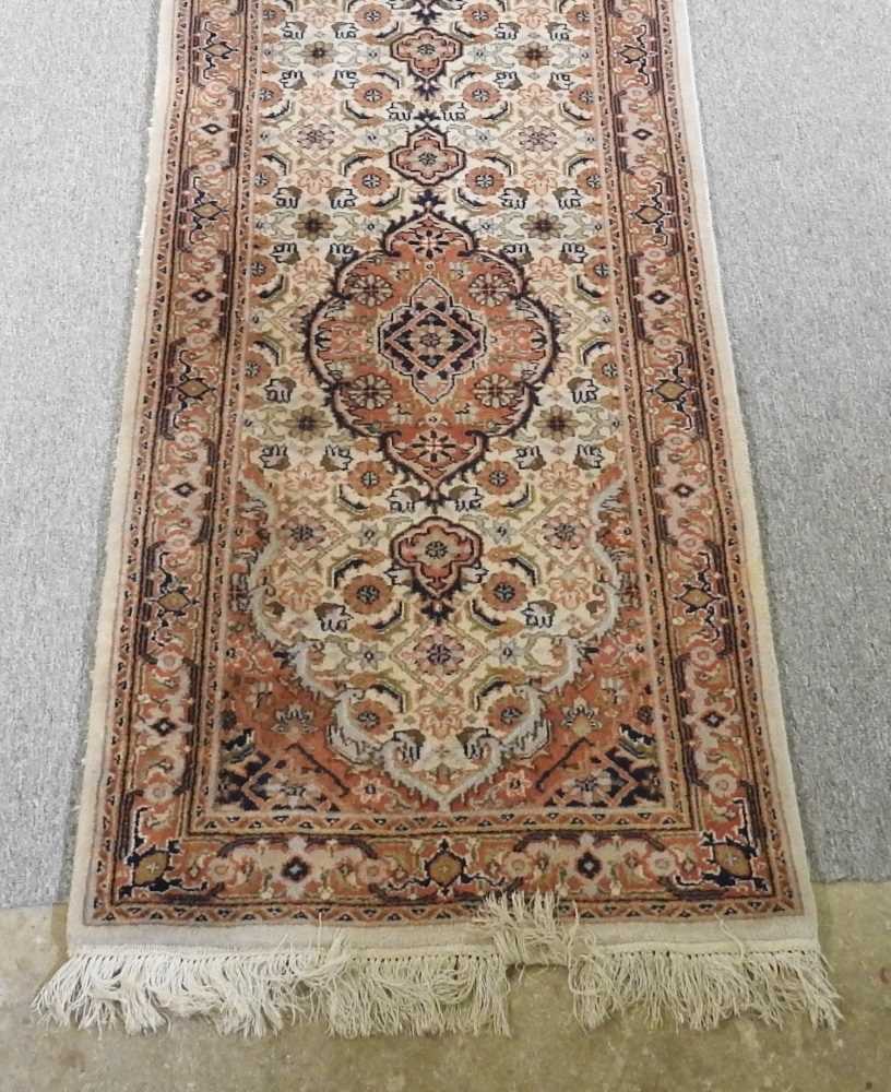A Persian runner, with a row of central medallions, on a cream ground, 300 x 75cm - Image 3 of 3