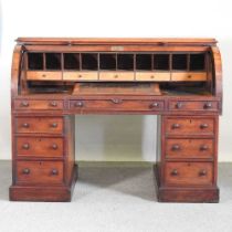 A large Victorian mahogany cylinder desk, the fitted interior with a sloping writing surface, on a