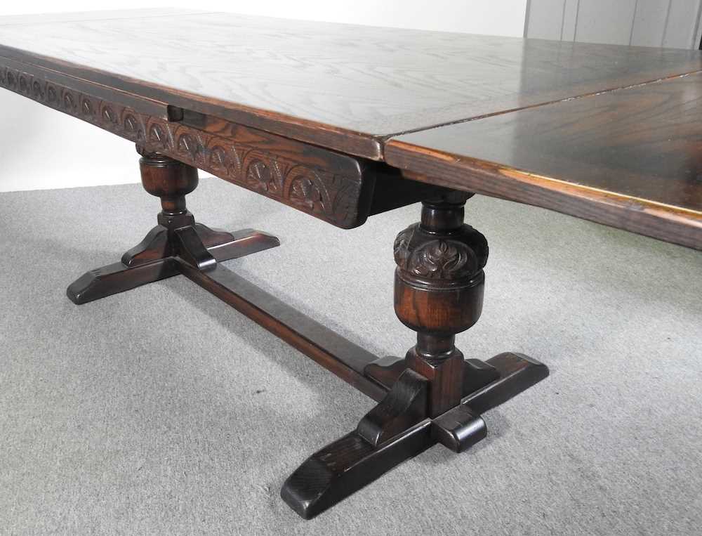 A mid 20th century oak draw leaf dining table, on cup and cover legs 275w x 92d x 76h cm - Image 2 of 5