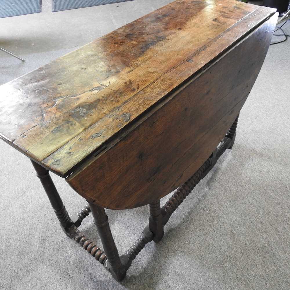 An 18th century oak gateleg table, with a hinged oval top, on bobbin turned legs 108w x 44d x 72h cm - Image 4 of 5