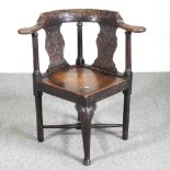 A George III and later carved oak corner chair