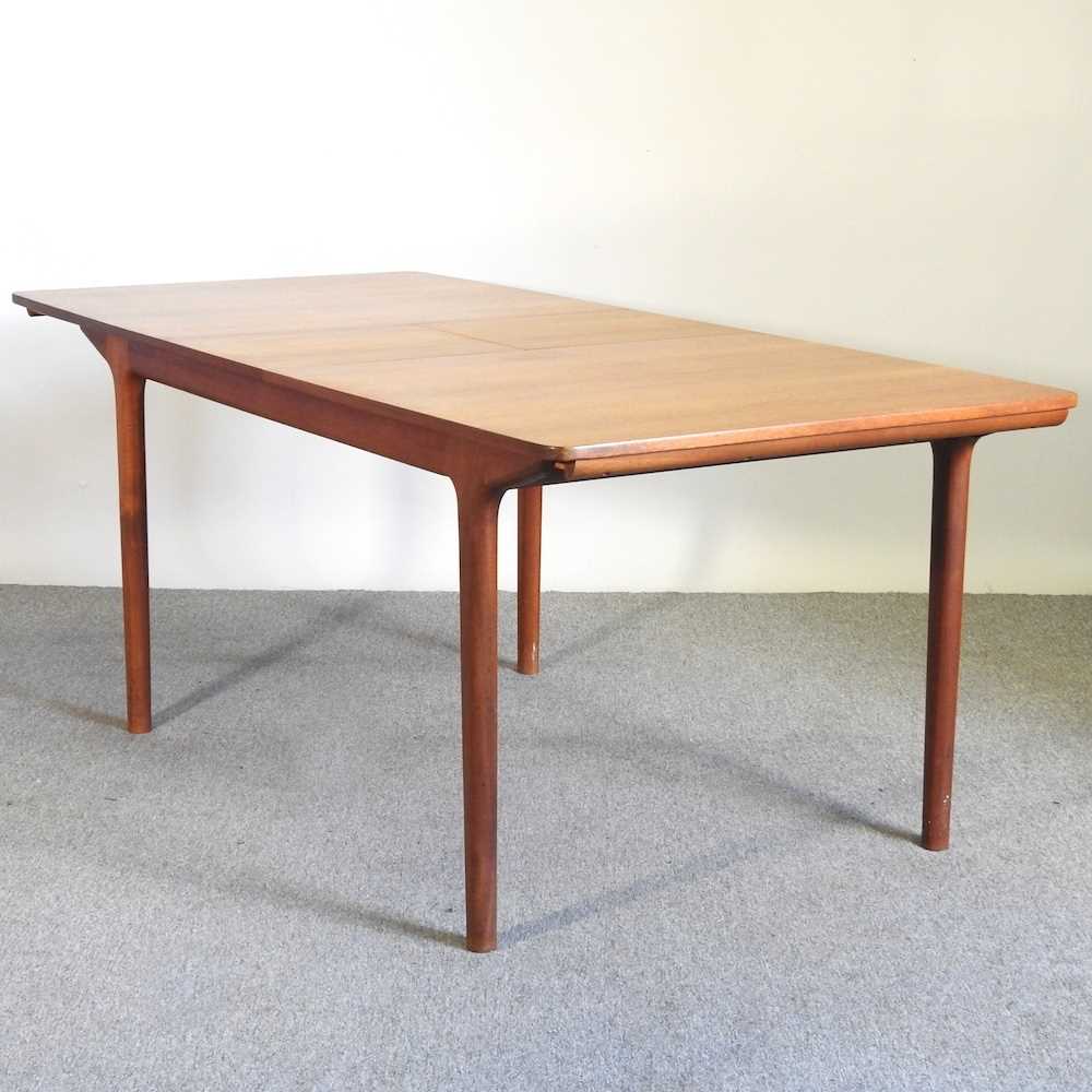 A 1970's teak extending dining table, with two additional leaves, bearing a label for A H McIntosh &