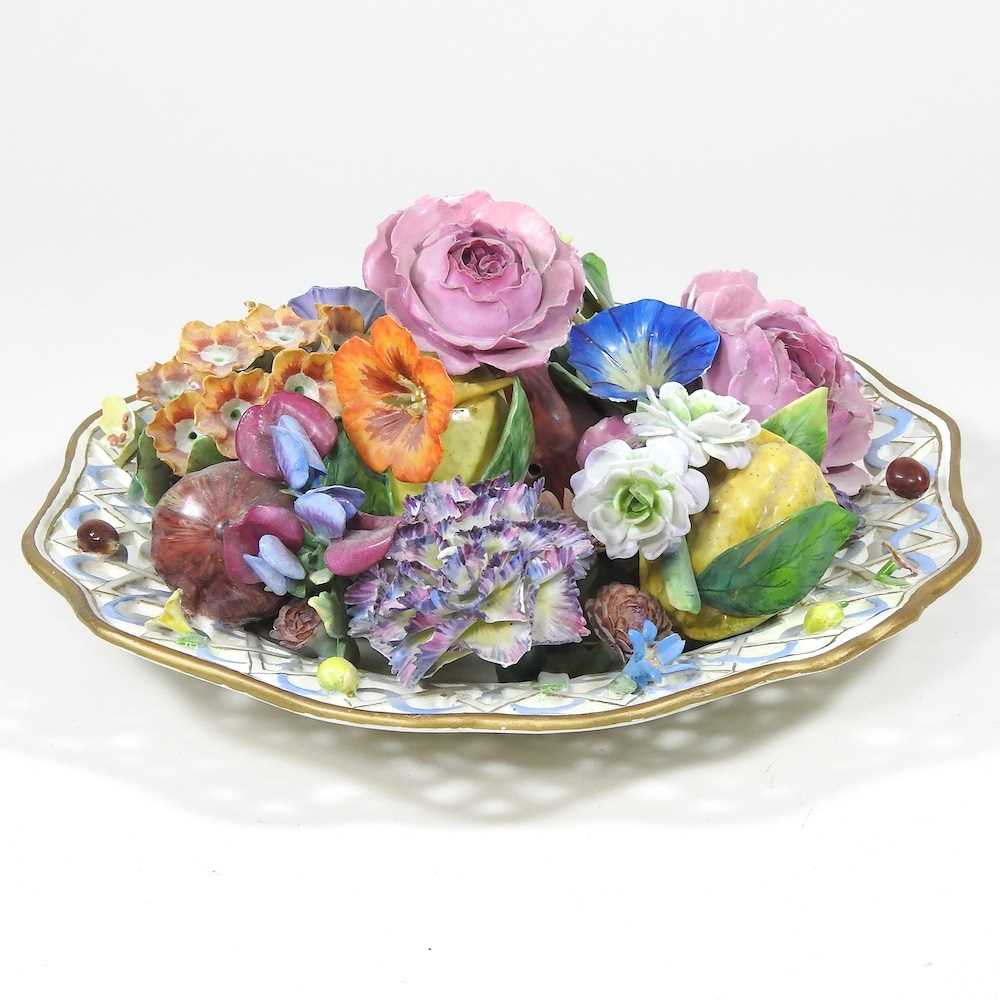 A 19th century Meissen porcelain trompe l'oeil plate, decorated with coloured flowers, within a