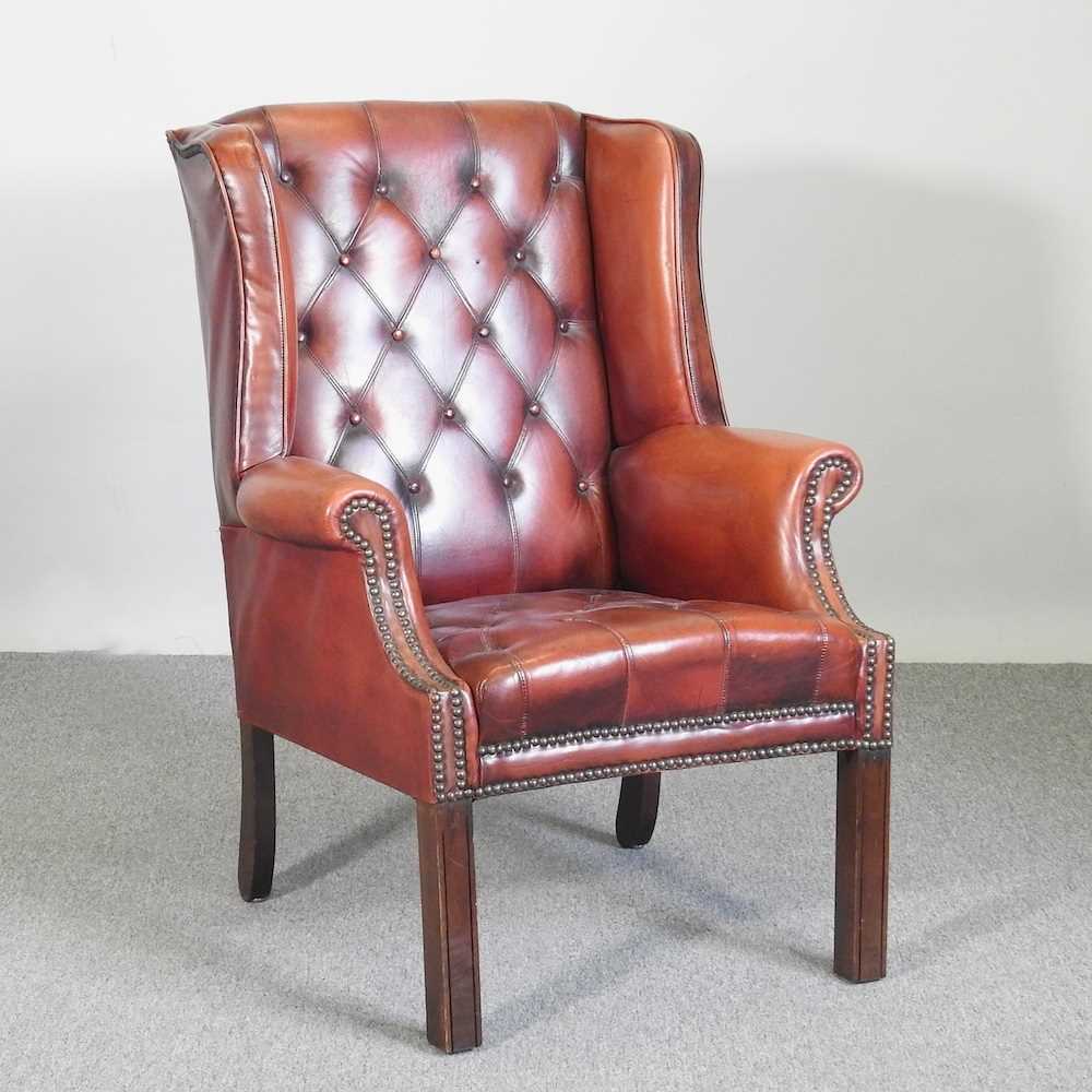 A Georgian style leather upholstered button back wing armchair, mid 20th century, on square legs