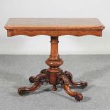 A Victorian burr walnut folding card table, the hinged rectangular top, on a carved column and