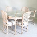 A carved wood and limed dining table, with a glass top, 107cm diameter, together with a set of