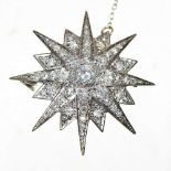 A diamond target brooch, of graduated star shape, with a pin back, unmarked, 11.8g, 4cm wide