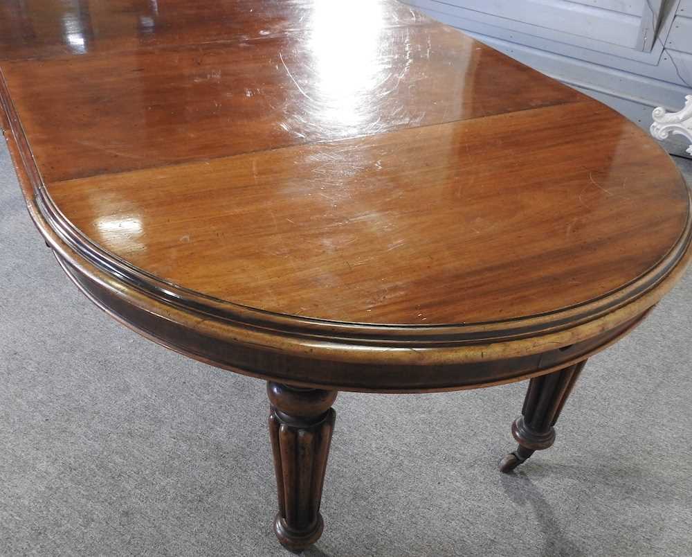 A Victorian mahogany oval wind out extending dining table, on turned and reeded legs, with two - Image 3 of 4