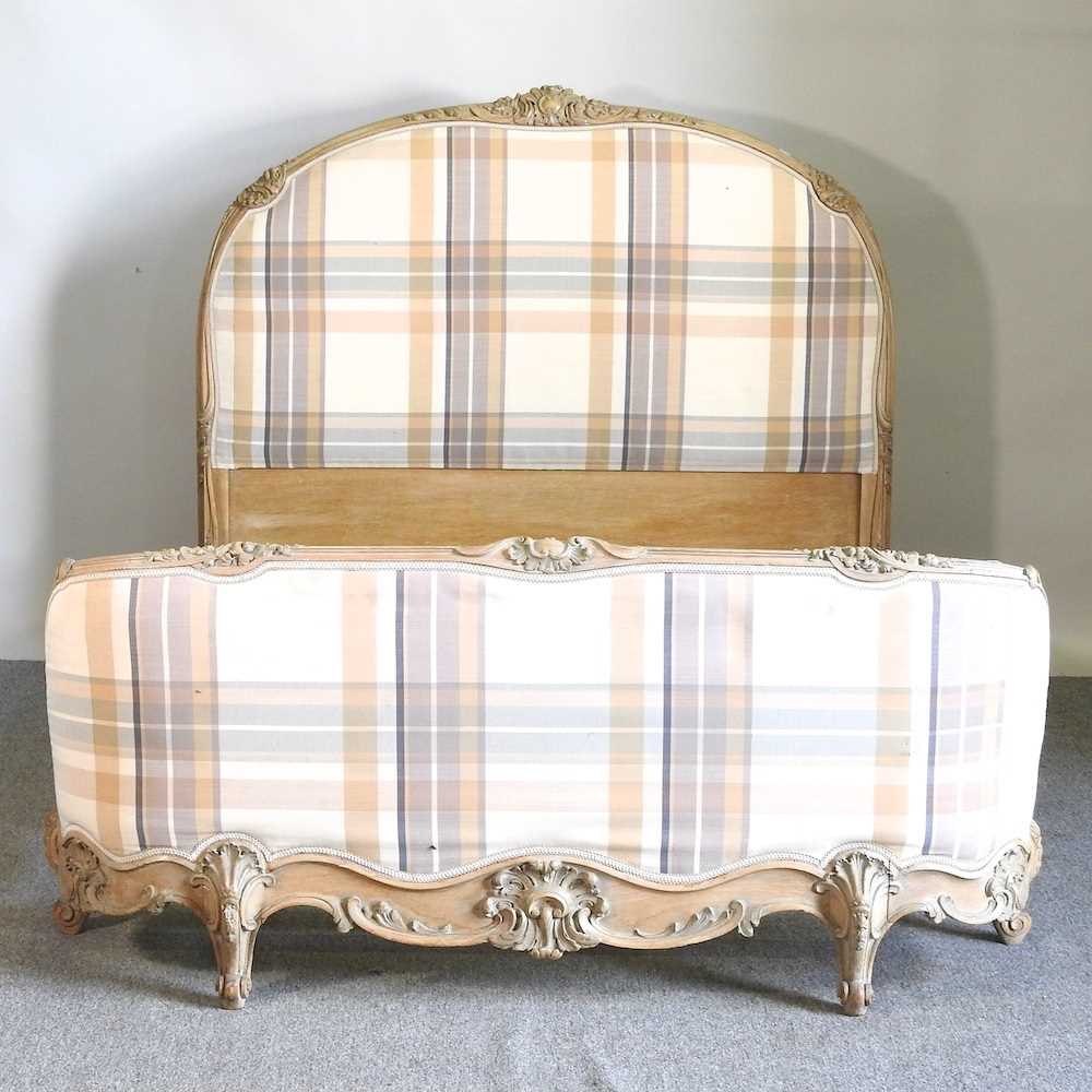 A later 20th century French limed and cream check upholstered double bedstead, with a slatted wooden