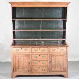 An 18th century Welsh oak dresser, having a boarded back, over an arrangement of short drawers and