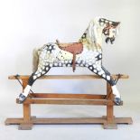 An early to mid 20th century painted wooden dappled grey rocking horse, on a wooden trestle base