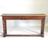 A carved oak console table, 20th century, on turned legs, united by a stretcher 137w x 36d x 71h cm