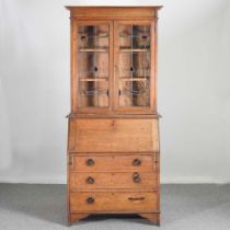 An early 20th century oak bureau bookcase, with stained leaded glass 92w x 41d x 206h cm