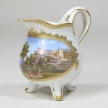 A 19th century Meissen style porcelain cream jug, reserved with a Veduta landscape, within a gilt