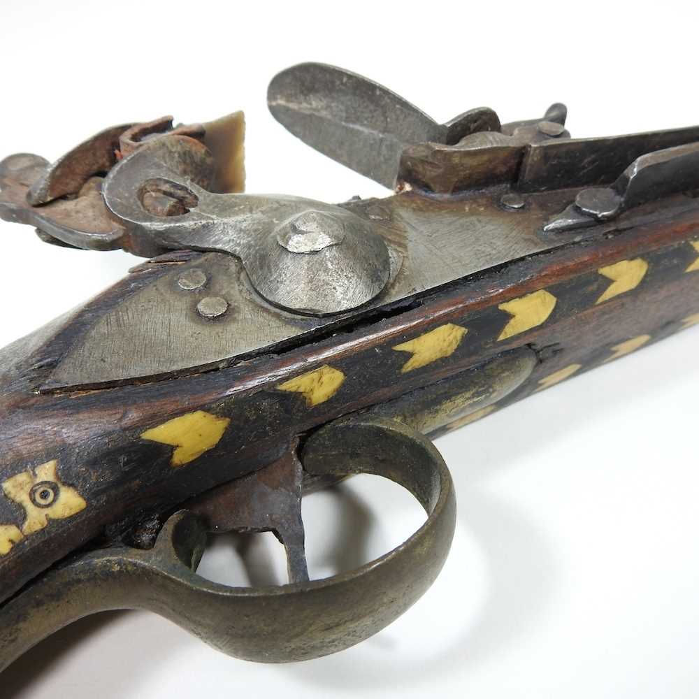 A middle Eastern flintlock pistol, with bone inlay, 40cm long Overall condition is complete. It is - Image 4 of 8