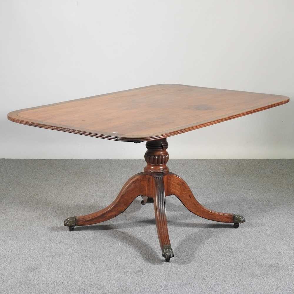 A Regency mahogany and crossbanded dining table, with a hinged top, on a splayed base 144w x 96d x