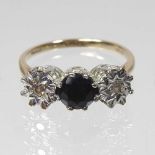 A 9 carat gold sapphire and diamond ring, the central brilliant cut sapphire, approximately 0.65