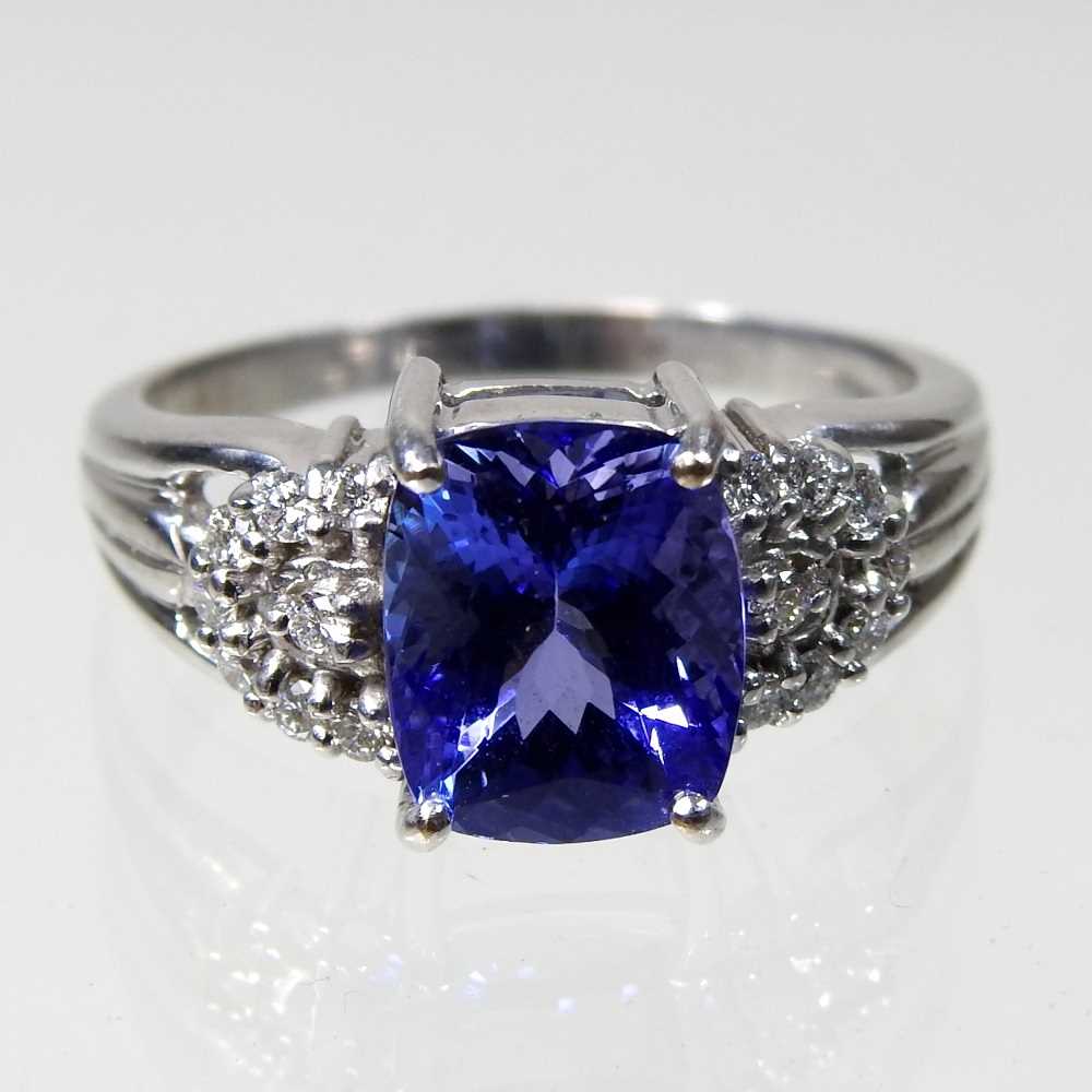 An 18 carat white gold, diamond and tanzanite dress ring, the central stone approximately three