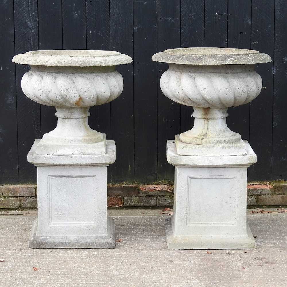 A pair of large simulated stone garden planters, each of fluted design, on a pedestal base (2) 72d x