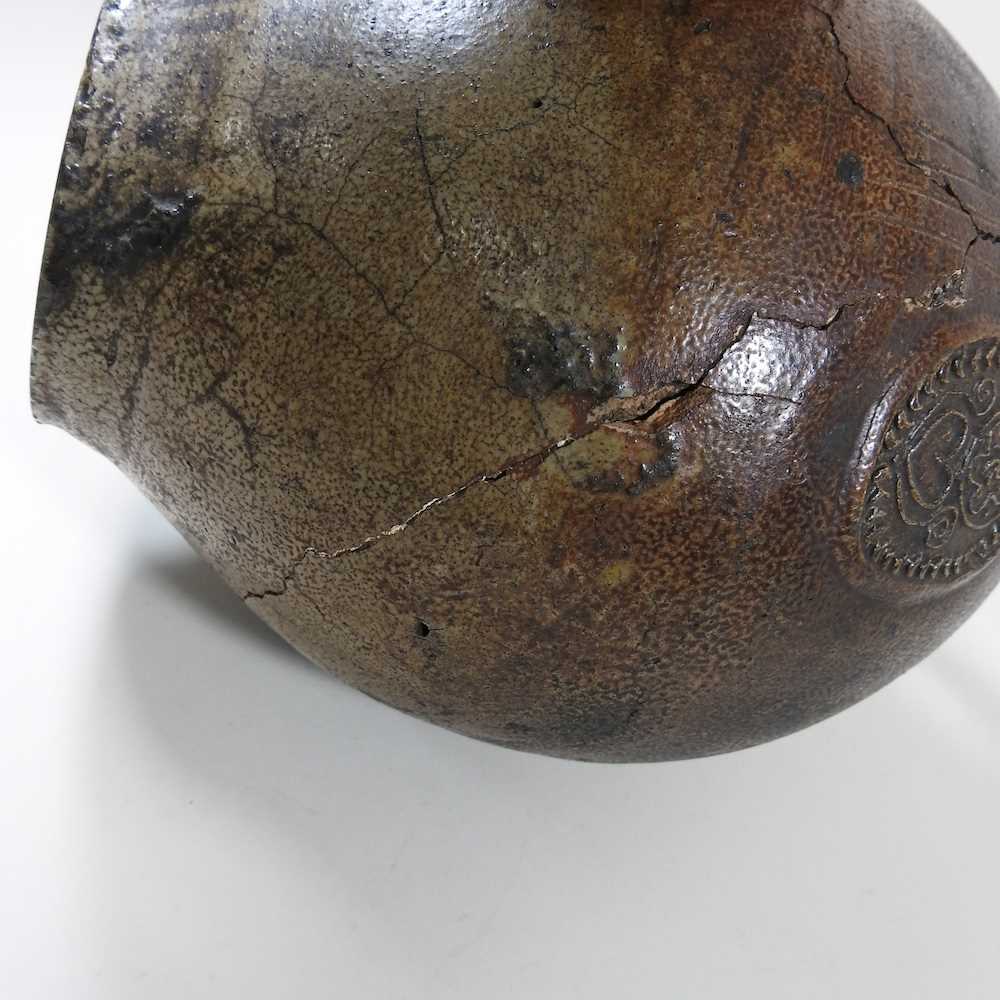 A 17th century German salt glazed stoneware bellarmine or Bartmann krug, of plain shape with a - Image 2 of 10