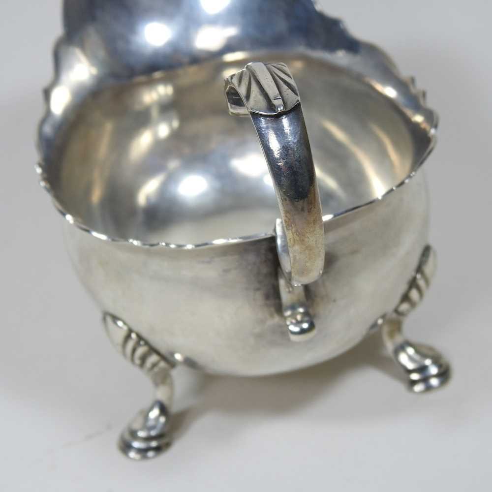 A George II silver sauce boat, of helmet shape, with a flying scrolled handle, on hoof feet, - Image 4 of 5