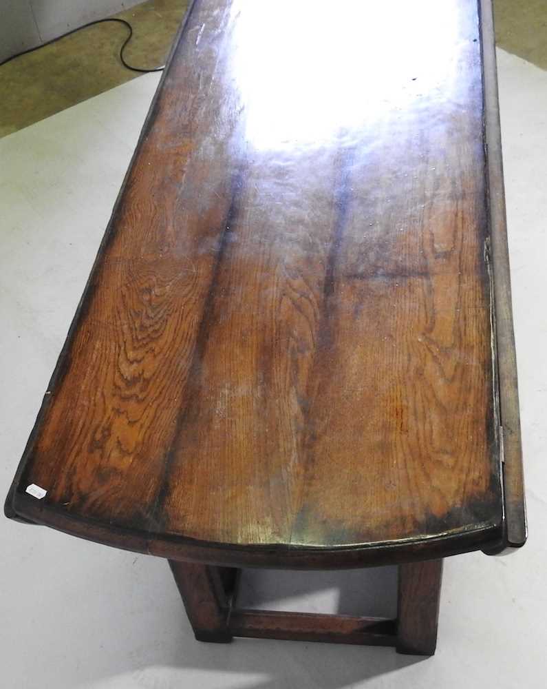 A large 18th century style oak wakes table, 20th century, the hinged oval top with a double gateleg, - Image 5 of 5