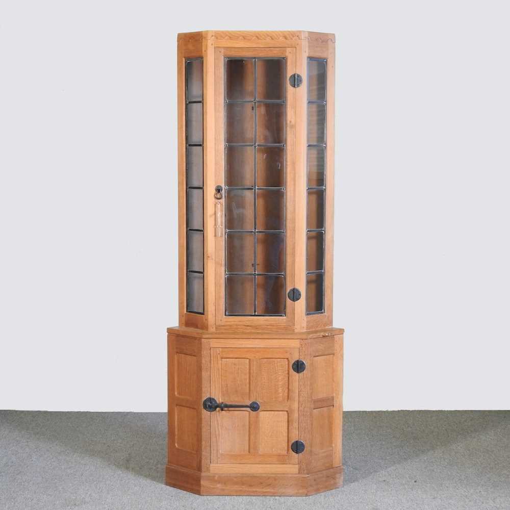 Robert 'Mouseman' Thompson, of Kilburn, a light oak standing corner cabinet, enclosed by a lead