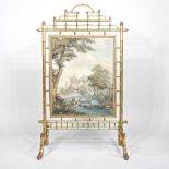 A 19th century simulated bamboo gilt fire screen, inset with a panel painted with a pastoral