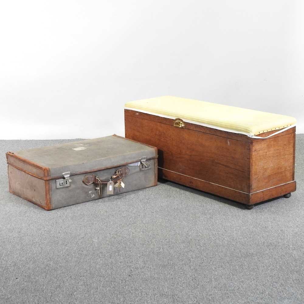 An early 20th century suitcase, together with a Victorian ottoman, with a padded top (2)