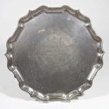 A mid 20th century silver salver, of circular shape, with a piecrust border, on hoof feet, with