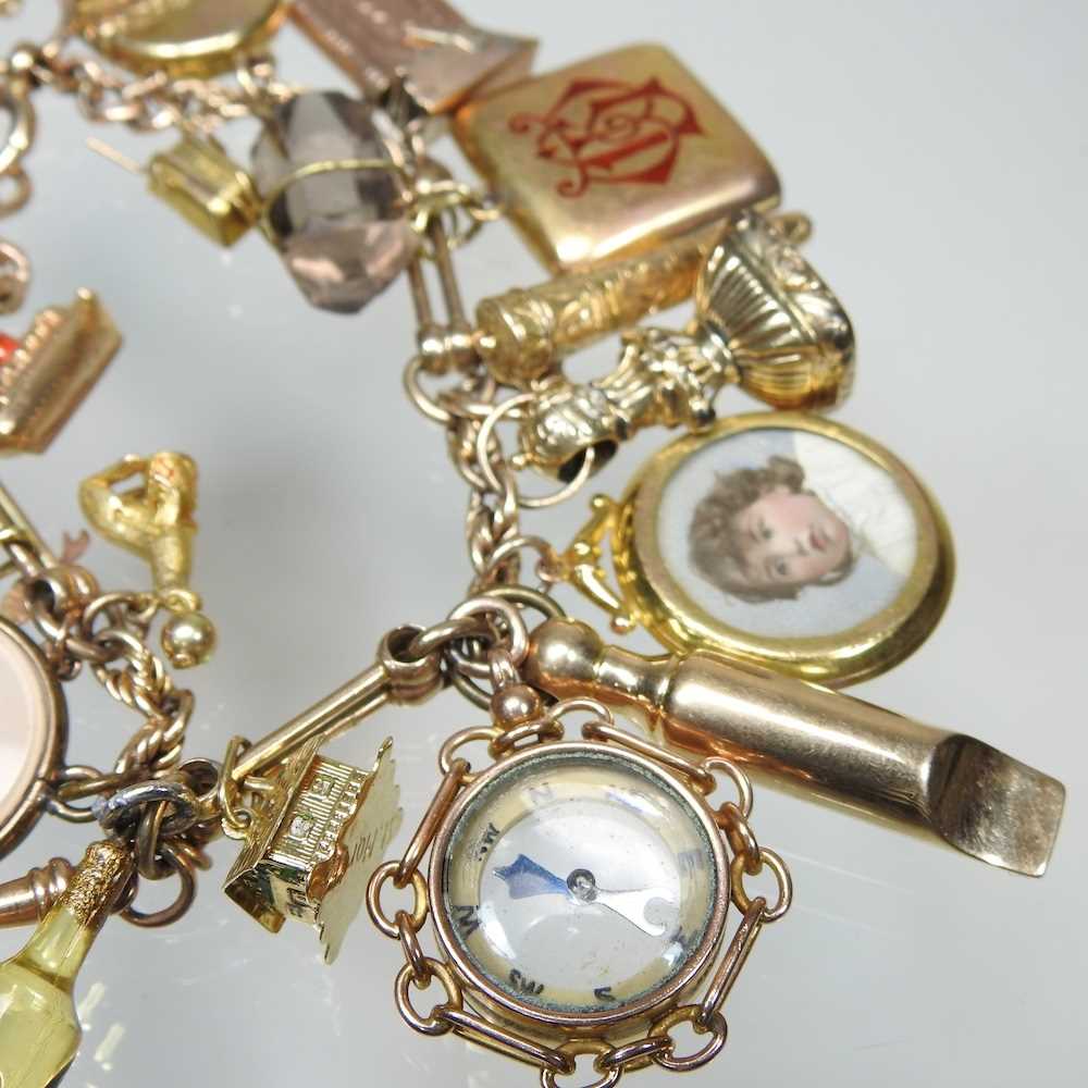 A gold charm bracelet, suspended with twenty-three various novelty charms, to include a sovereign - Image 5 of 12