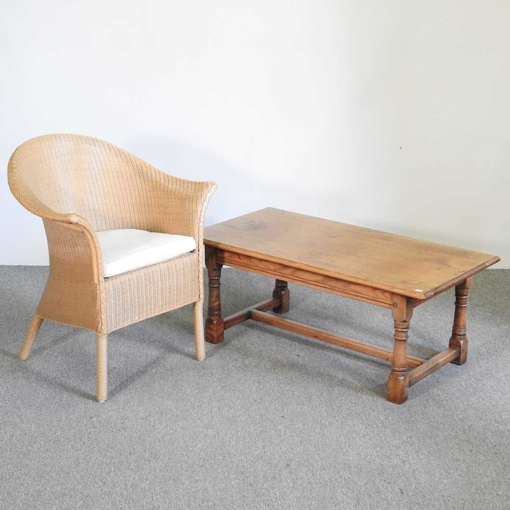 An oak coffee table, 107cm wide, together with a Lloyd Loom style bergere chair (2)