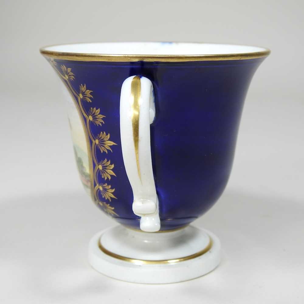 An early 19th century Derby porcelain twin handled cup, reserved with a river landscape, on a blue - Image 7 of 7