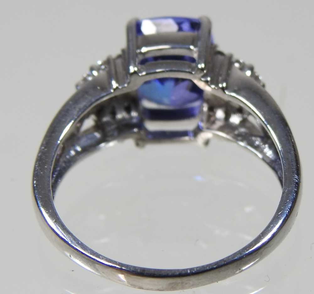 An 18 carat white gold, diamond and tanzanite dress ring, the central stone approximately three - Image 4 of 6