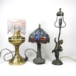 A converted brass oil lamp, together with a Tiffany style table lamp and a figural table lamp (3)