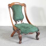 A Victorian carved walnut and green upholstered nursing chair, on cabriole legs