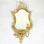 A Rococo style gilt framed girandole, 20th century, of cartouche shape, with a scrolled surround and