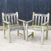 A pair of teak garden arm chairs