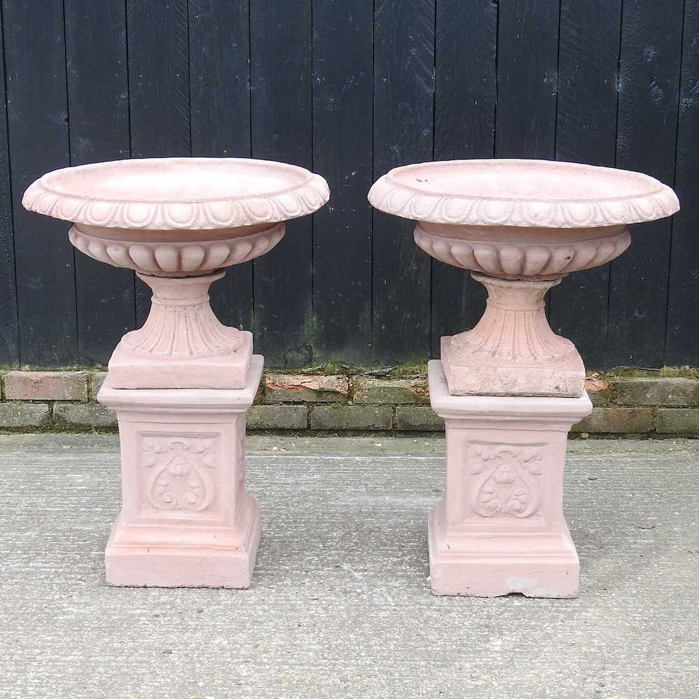 A pair of terracotta style garden urns, on stands, 83cm high (2) 62cm wide