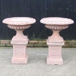 A pair of terracotta style garden urns, on stands, 83cm high (2) 62cm wide